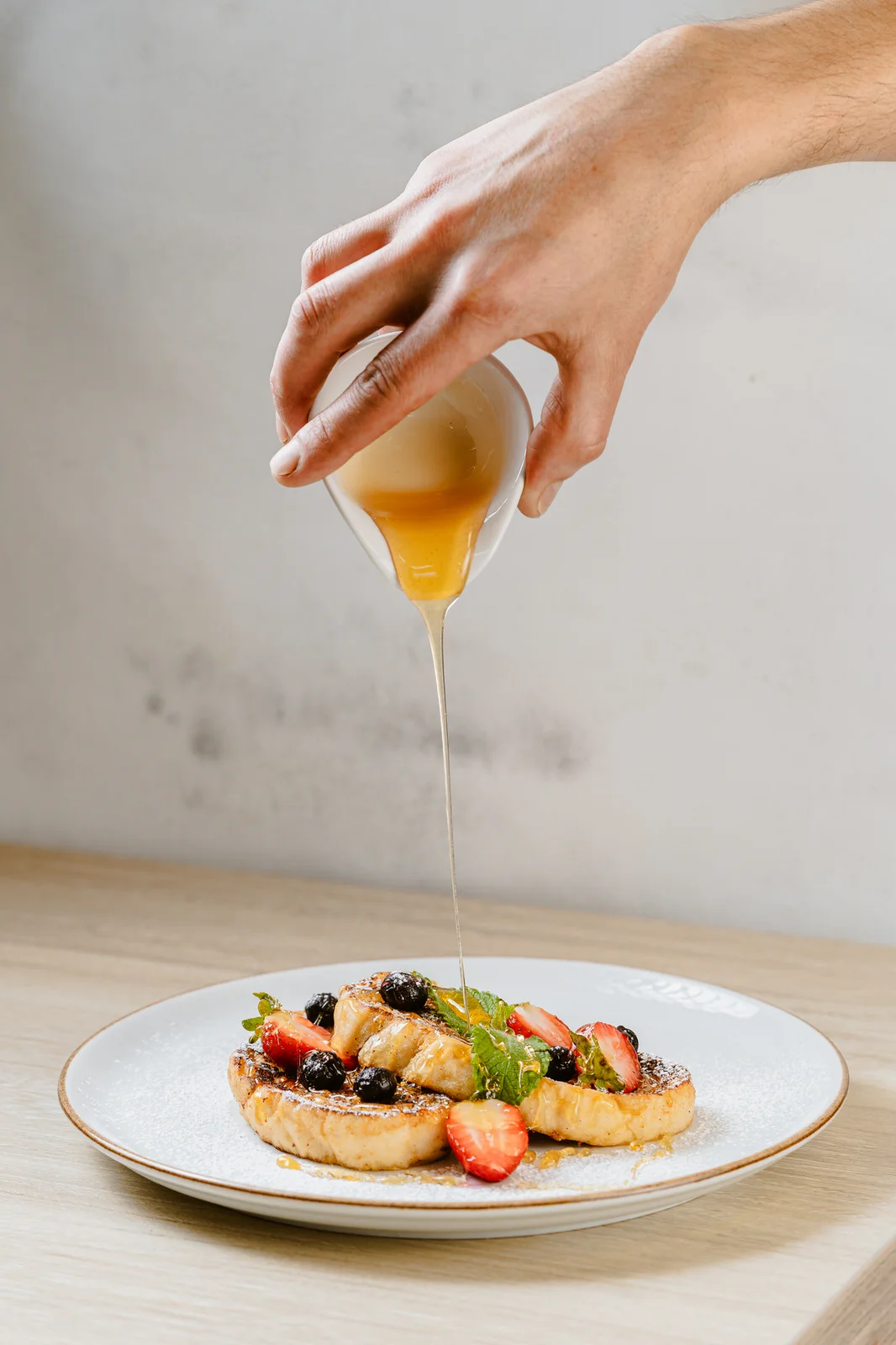Fotografía gastronómica postre mano salsa fondo blanco restaurante