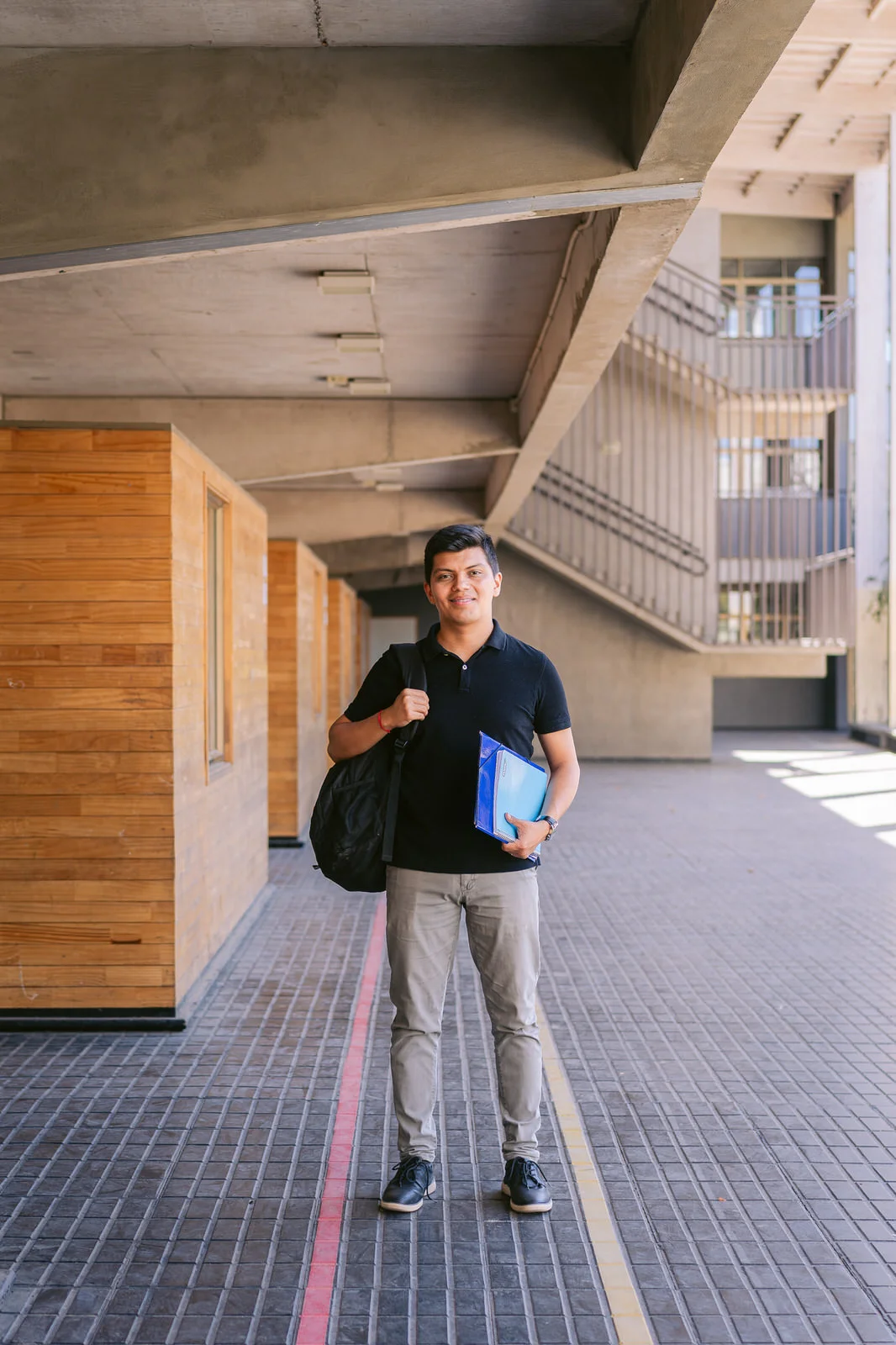Hombre con mochila caminando por pasillo de colegio — Elige Educar Mineduc