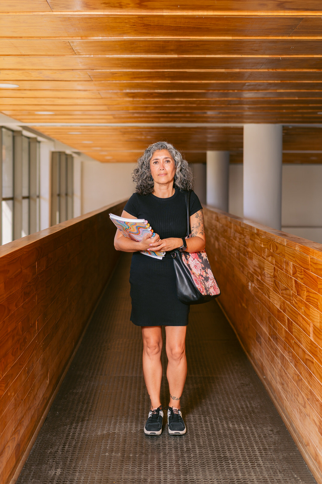 Mujer caminando por pasillo de madera de colegio — Elige Educar Mineduc