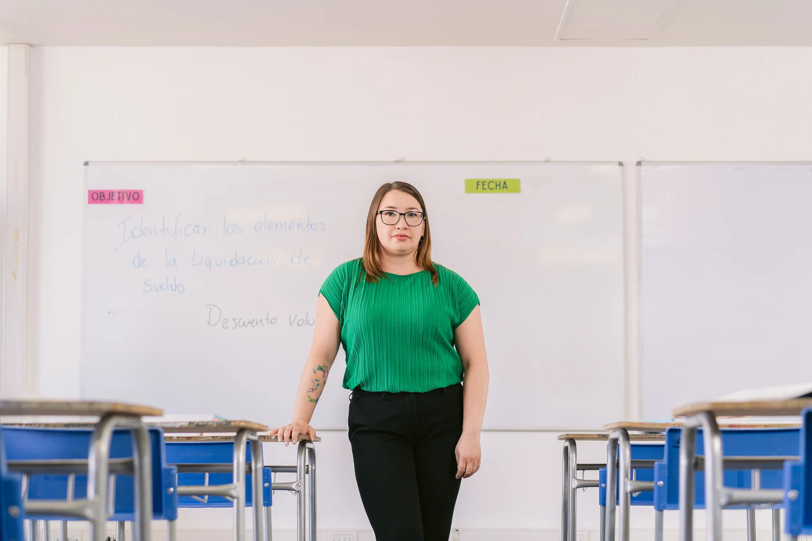 Profesora de pie junto a pizarra en aula — campaña Elige Educar Mineduc