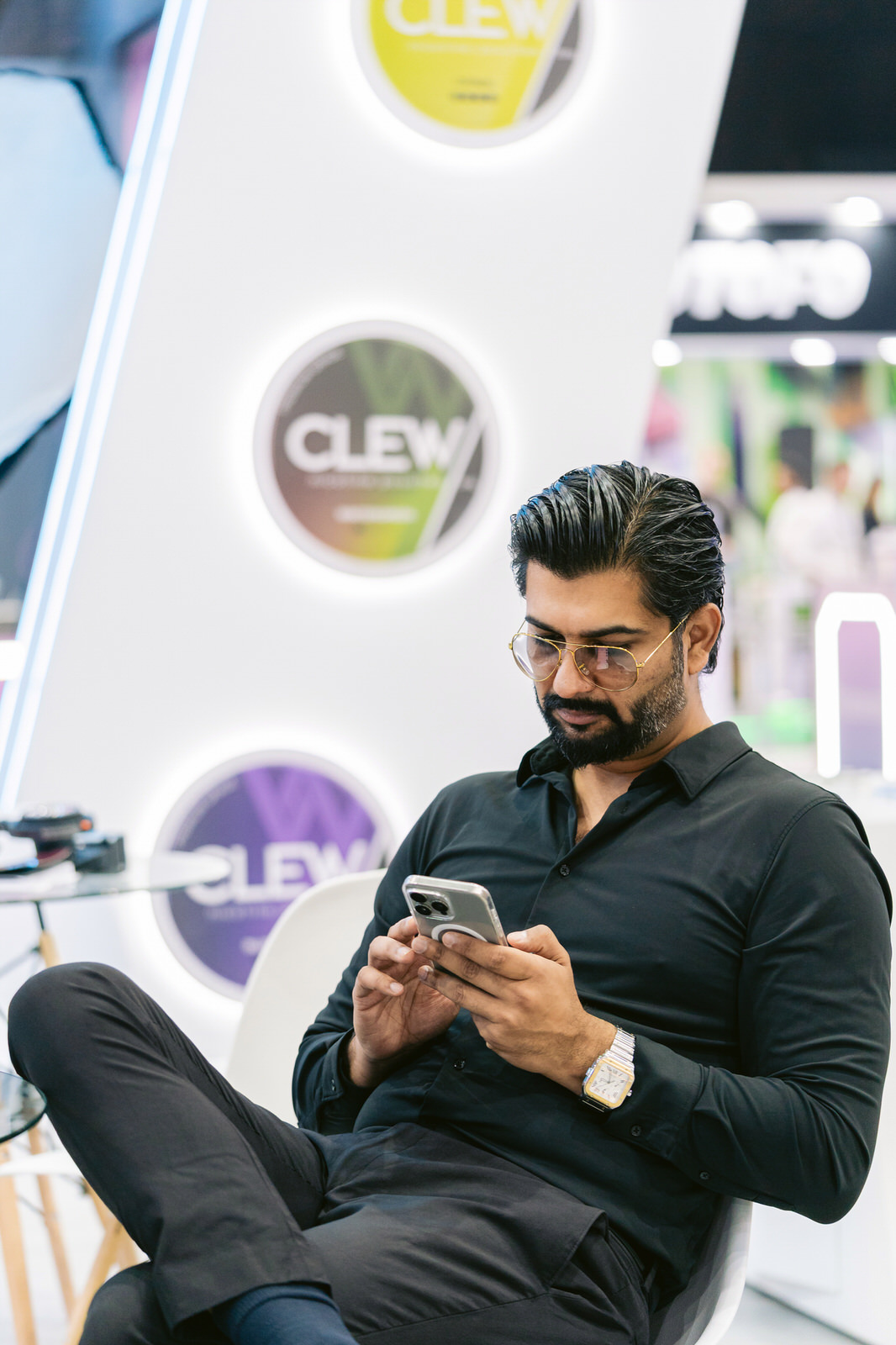 Clew World Vaper Show 2025 — hombre sentado stand telefono