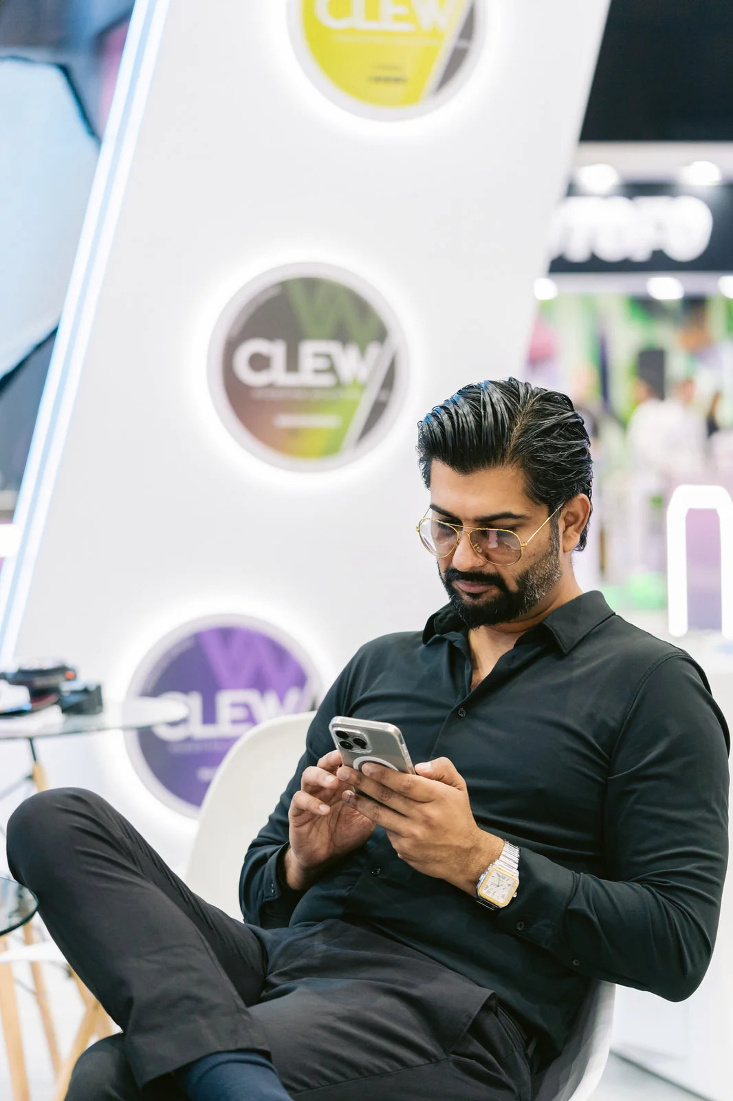 Clew World Vaper Show 2025 — hombre sentado stand telefono