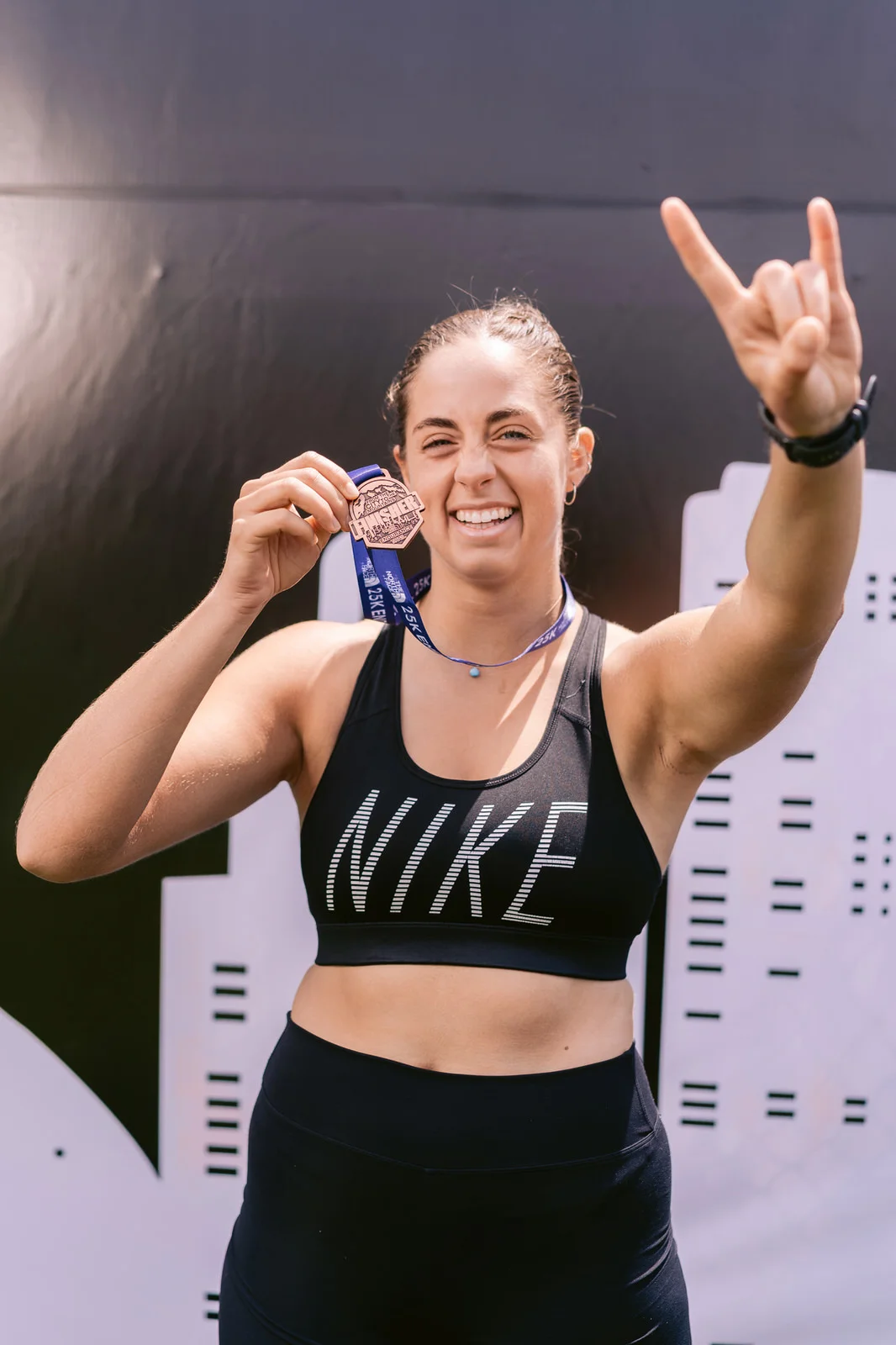 Kifit TNF Endurance Trail 2025 — retrato mujer nike medalla gesto