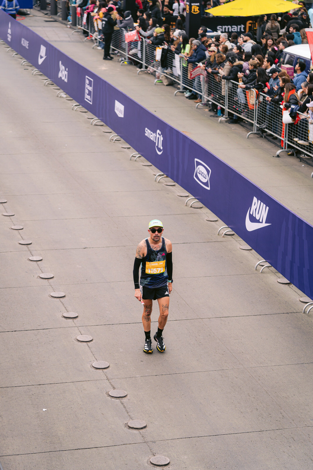 Maratón de Santiago 2025 — corredor solitario meta bandera